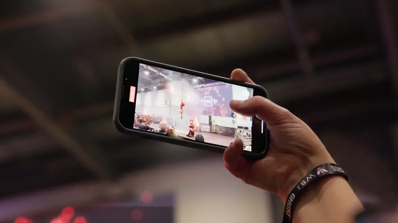 An audience member filming a live performance on a phone