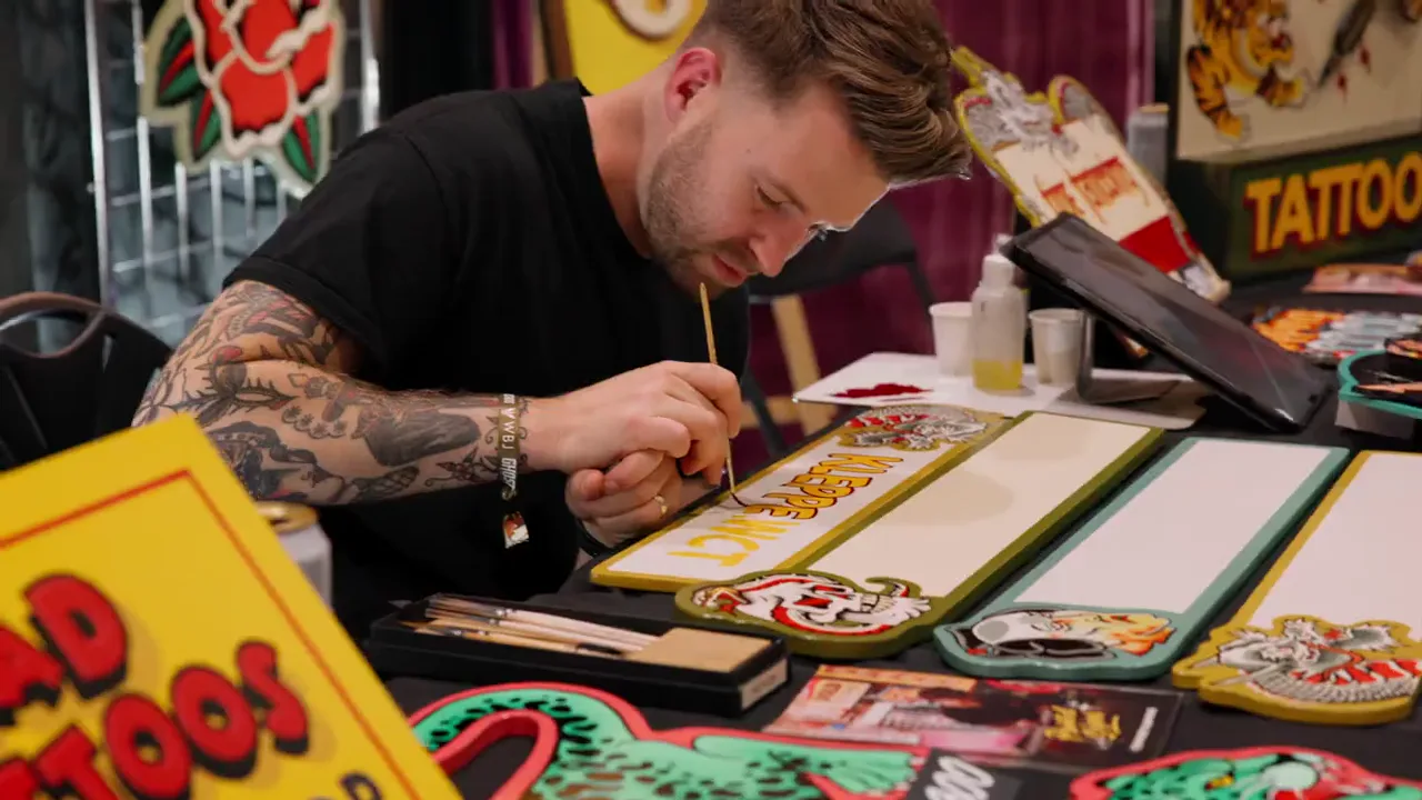 An artist working at a tattoo stand