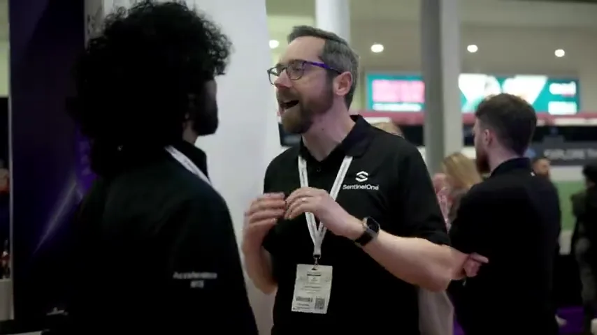 People in conversation beside SentinelOne event branding