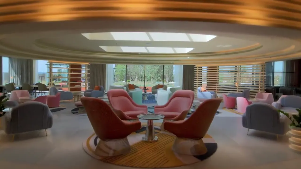 The Arc resident lounge with curved windows and coral seating
