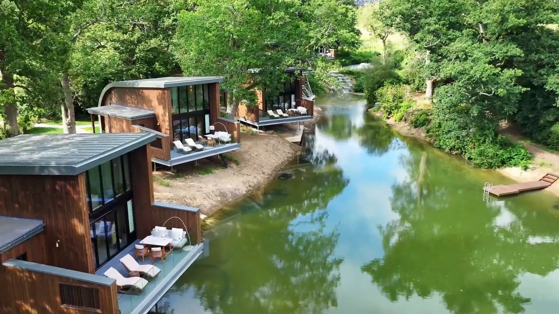 The Reeds lodges seen across the water and woodland