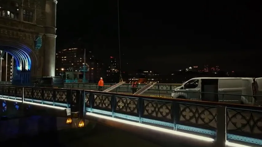 Maintenance workers on the Tower Bridge walkway at night